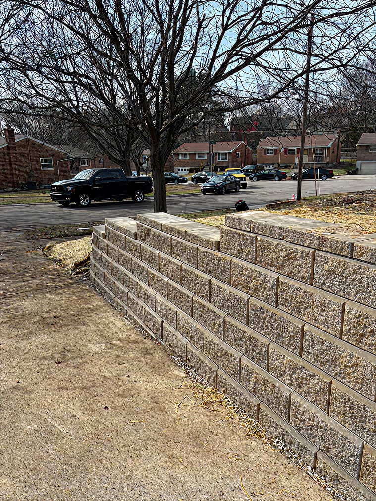 Block retaining wall along driveway built by Trademark Outdoor Services